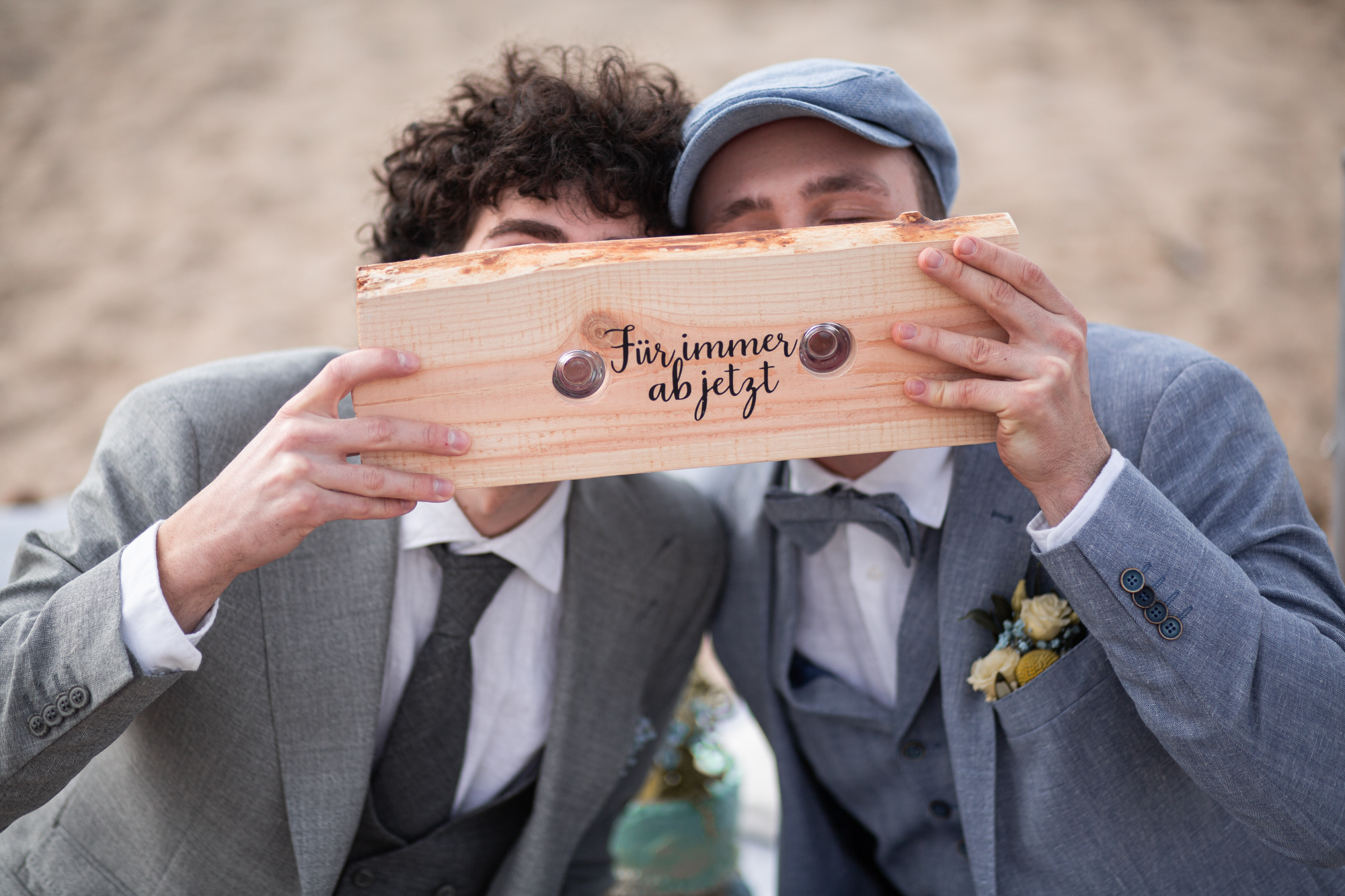 Gleichgeschlechtliches Hochzeitspaar bei einem persönlichen Trauritual mit Schnapsbrett – Für immer ab jetzt